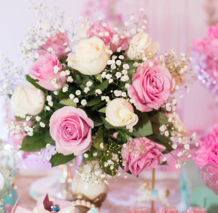 Enchanting Sacramento Floral Design Company Crafting Bouquets of Pink and White Roses with Baby's Breath, Evoking Festive Delight.