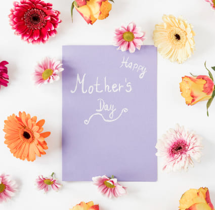 A mother's day card surrounded by a variety of colorful flowers on a white background.