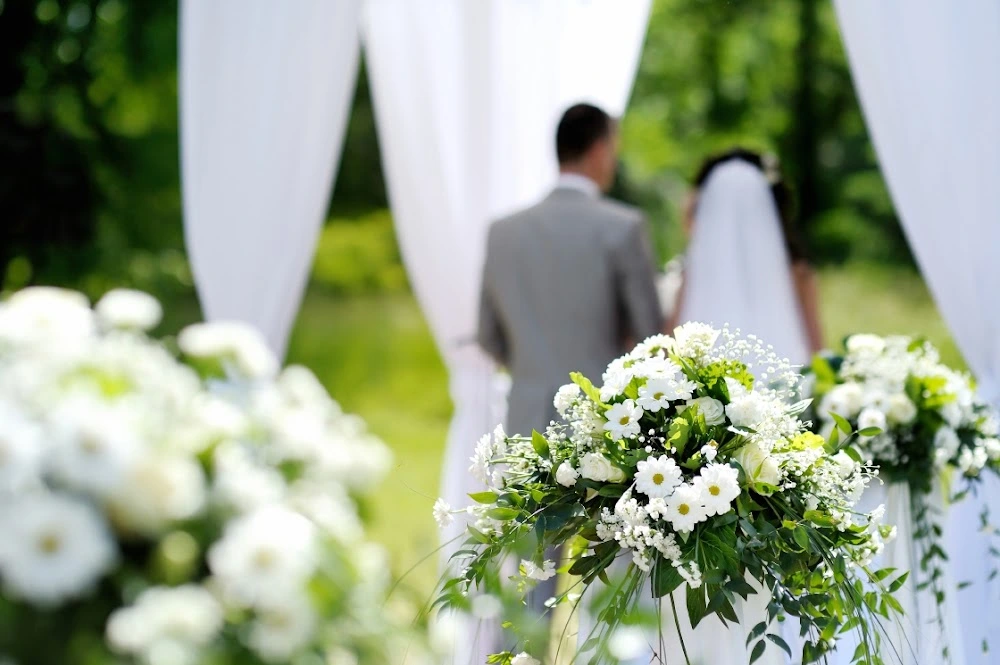 Best Wedding Florist Crafting Stunning Outdoor Ceremony Displays, Accentuating Floral Decorations with a Beautiful Altar Backdrop.